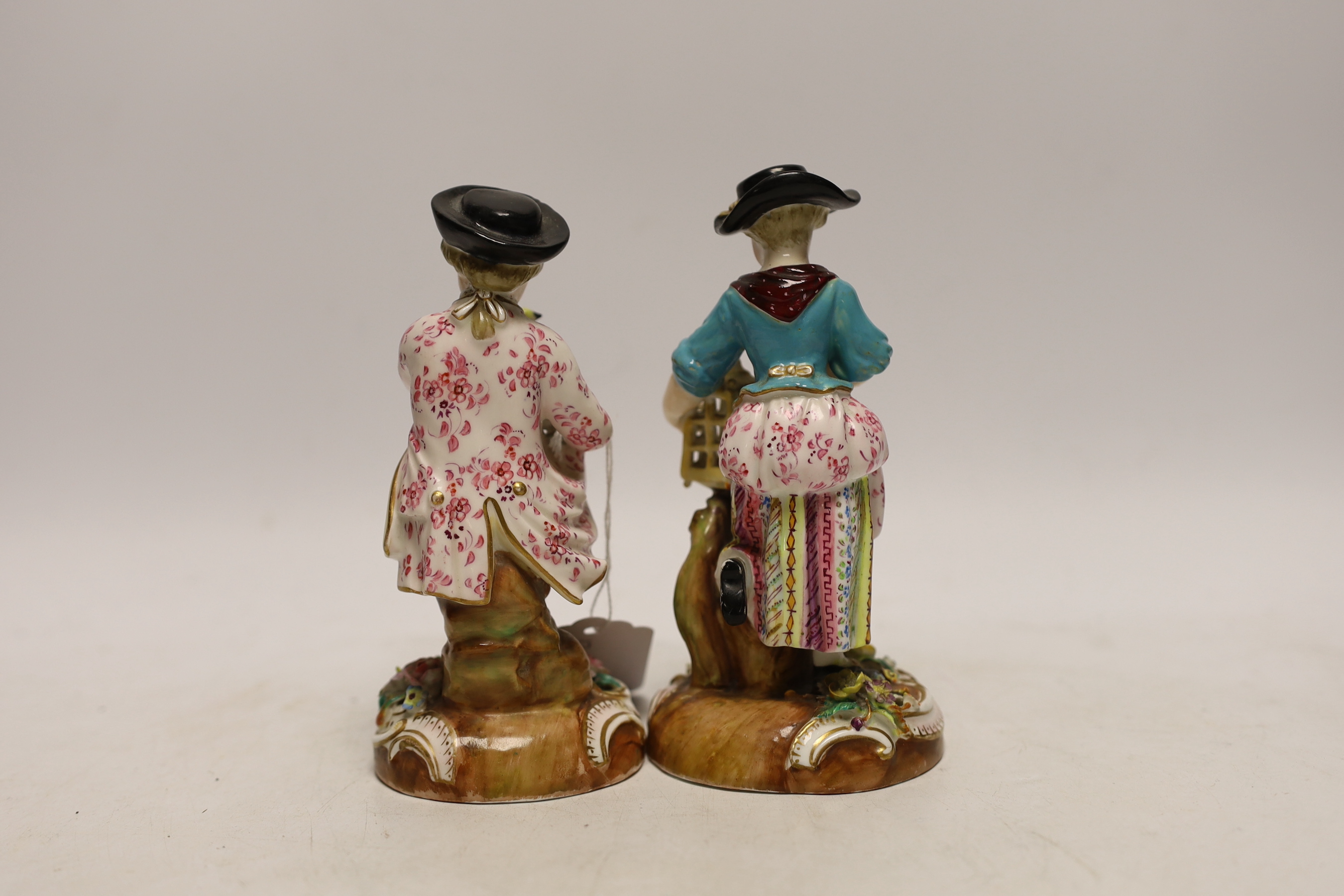A pair of John Bevington figures, late 19th century, both holding birds with floral encrusted bases, 15.5cm